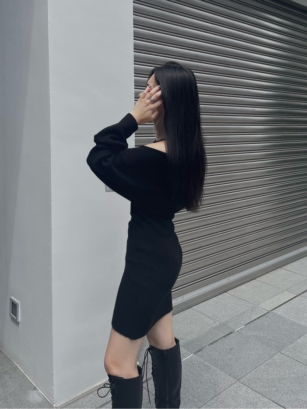 ブラック系のブーツ、ブラック系のワンピース、ブラック系のボストンバッグを着用したレディースの秋コーディネートの5枚目の写真