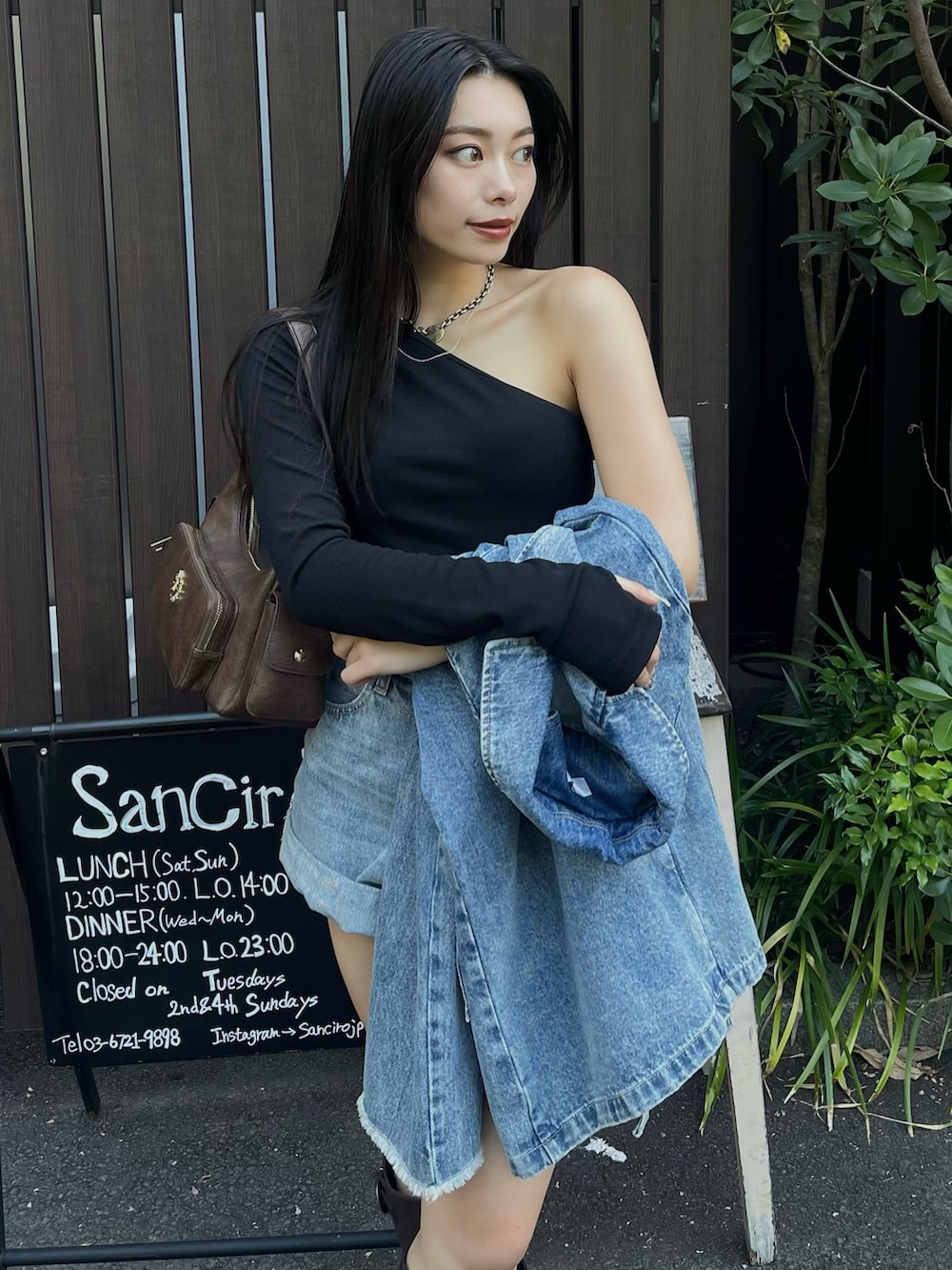 ブルー系のデニムジャケット、ブラック系のTシャツ/カットソー、ブラウン系のブーツを着用したレディースの夏コーディネートの4枚目の写真