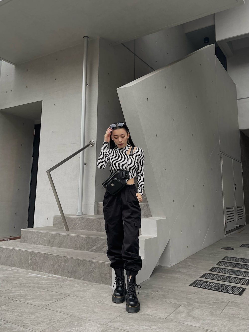 ブラック系のボディバッグ/ウエストポーチ、ブラック系のTシャツ/カットソーを着用したレディースの冬コーディネートの2枚目の写真