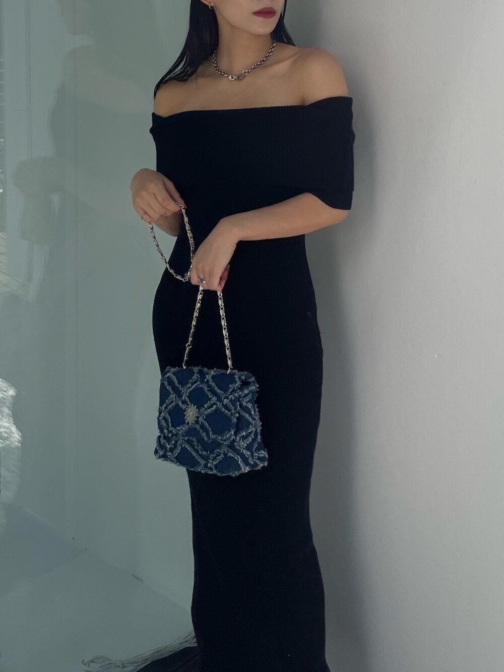 ブラック系のワンピース、ブルー系のショルダーバッグを着用したレディースの秋コーディネートの5枚目の写真