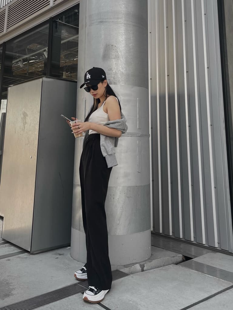 ブラック系のスラックス、グレー系のカーディガン/ボレロ、ホワイト系のキャミソールを着用したレディースの春コーディネートの3枚目の写真