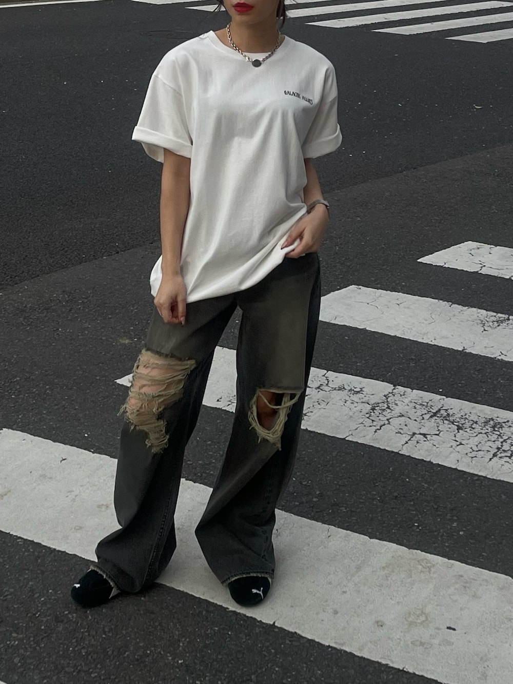 ホワイト系のTシャツ/カットソー、ブラック系のデニムパンツ、ブラック系のスニーカーを着用したレディースの春コーディネートの2枚目の写真