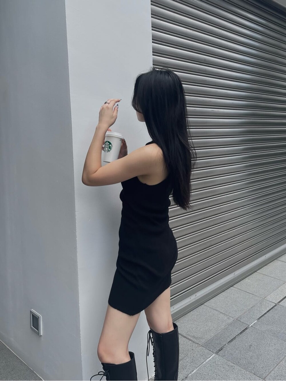 ブラック系のブーツ、ブラック系のワンピース、ブラック系のボストンバッグを着用したレディースの秋コーディネートの7枚目の写真