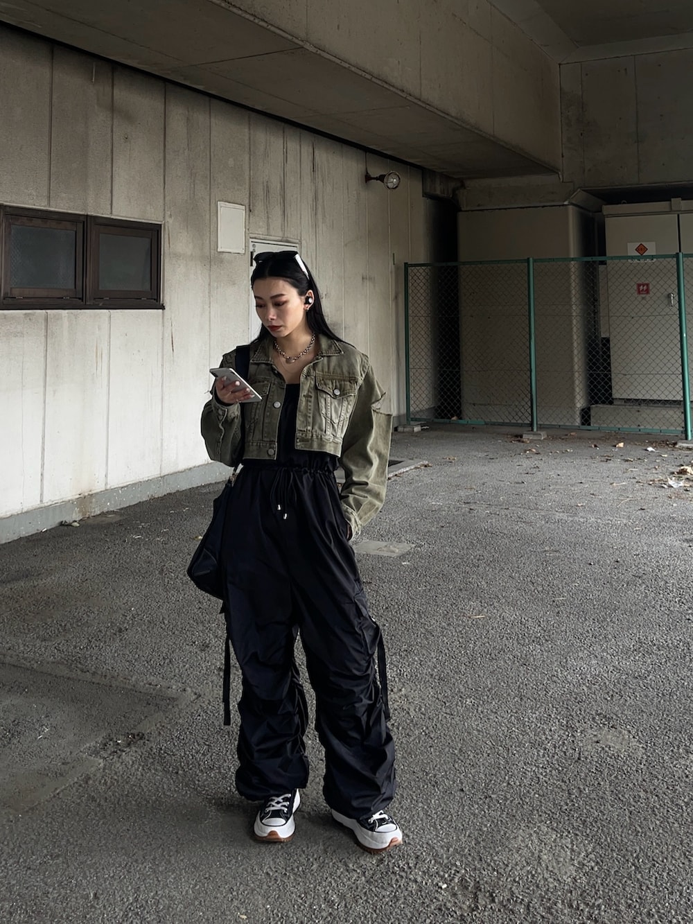 グリーン系のデニムジャケット、ブラック系のつなぎ/オールインワンを着用したレディースの春コーディネートの2枚目の写真