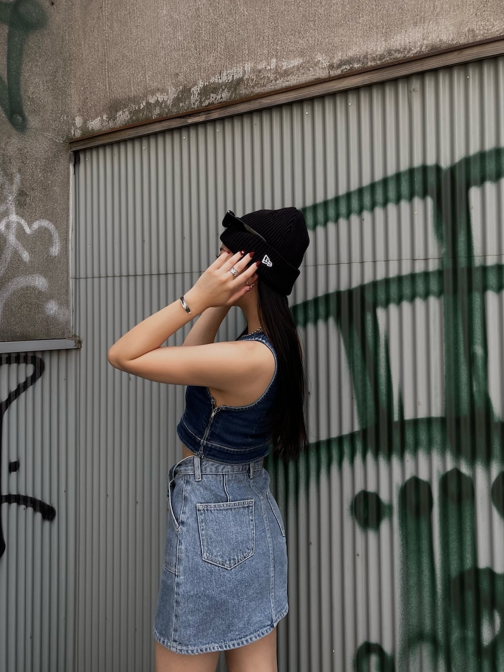 ブルー系のキャミソール、ブルー系のデニムスカートを着用したレディースの夏コーディネートの7枚目の写真