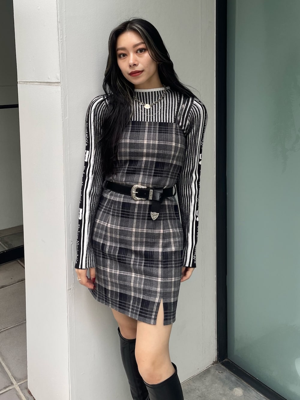 ブラック系のニット/セーター、ブラック系のワンピース、ブラック系のブーツを着用したレディースの秋コーディネートの3枚目の写真