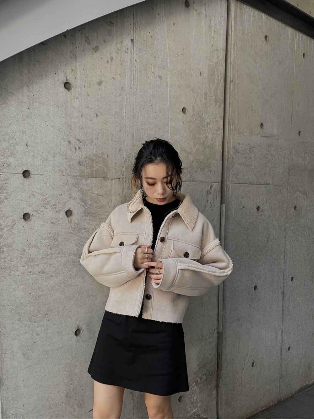 ブラック系のニット/セーター、ブラック系のブーツ、ホワイト系のブルゾンを着用したレディースの冬コーディネートの6枚目の写真