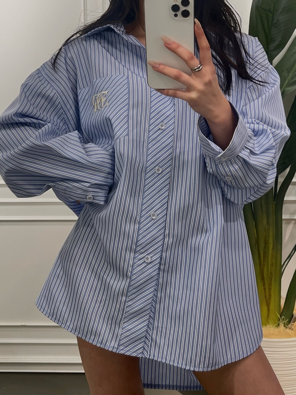 ブルー系のシャツ/ブラウス、ブラック系のブーツを着用したレディースの春コーディネートの3枚目の写真