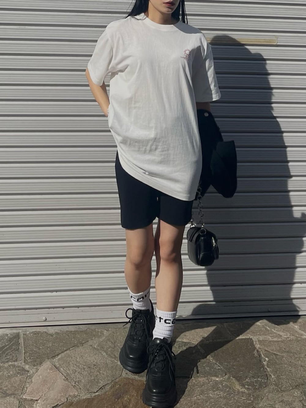 ホワイト系のTシャツ/カットソー、ブラック系のその他パンツ、ブラック系のスニーカーを着用したレディースの春コーディネートの5枚目の写真