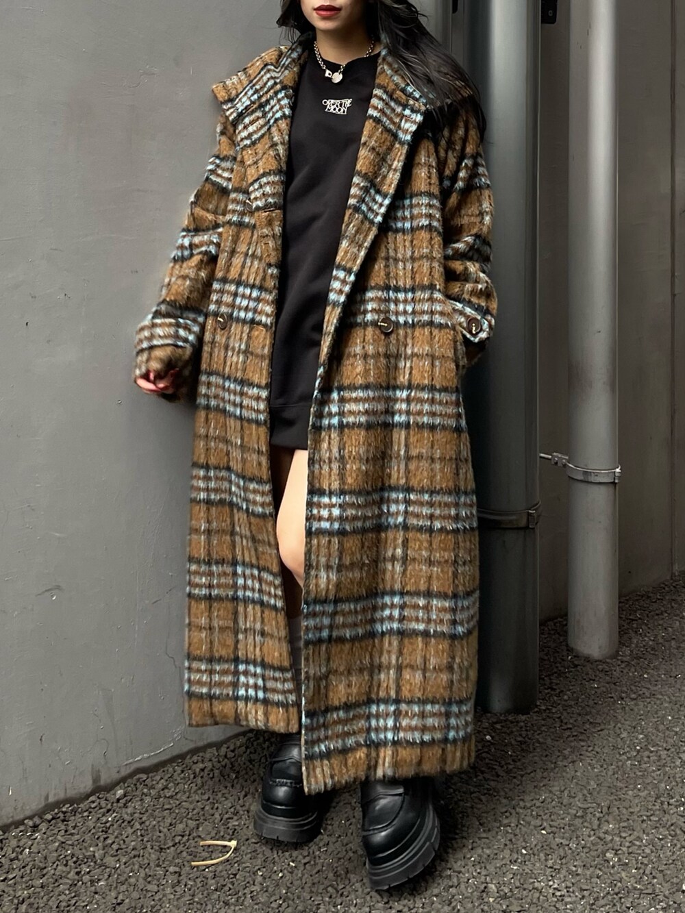 その他のチェスターコート、ブラック系のスウェット、ブルー系のデニムスカートを着用したレディースの秋コーディネートの5枚目の写真