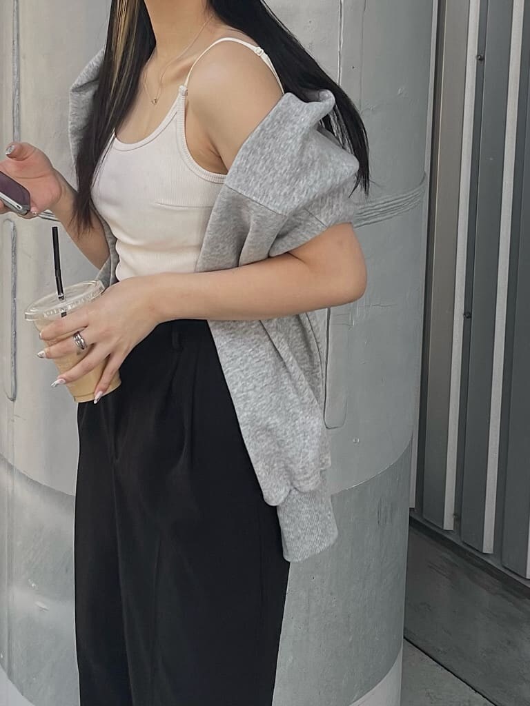 ブラック系のスラックス、グレー系のカーディガン/ボレロ、ホワイト系のキャミソールを着用したレディースの春コーディネートの6枚目の写真