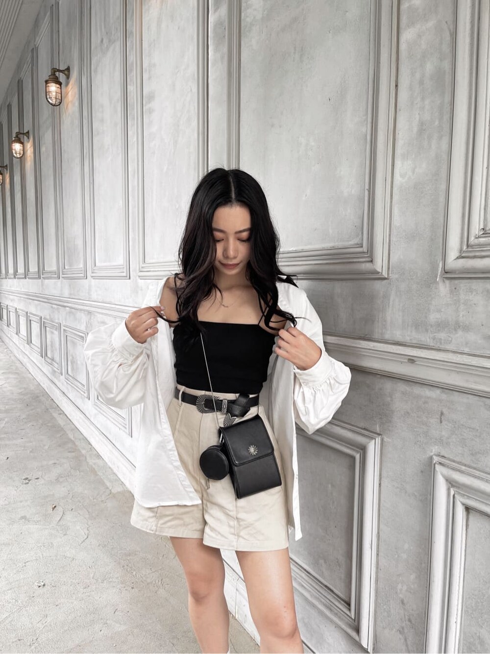ホワイト系のシャツ/ブラウス、ブラック系のベルトを着用したレディースの夏コーディネートの3枚目の写真