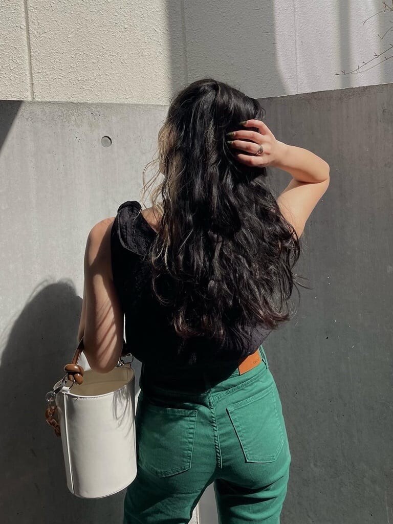 ブラック系のシャツ/ブラウス、ホワイト系のショルダーバッグ、グリーン系のデニムパンツを着用したレディースの春コーディネートの5枚目の写真