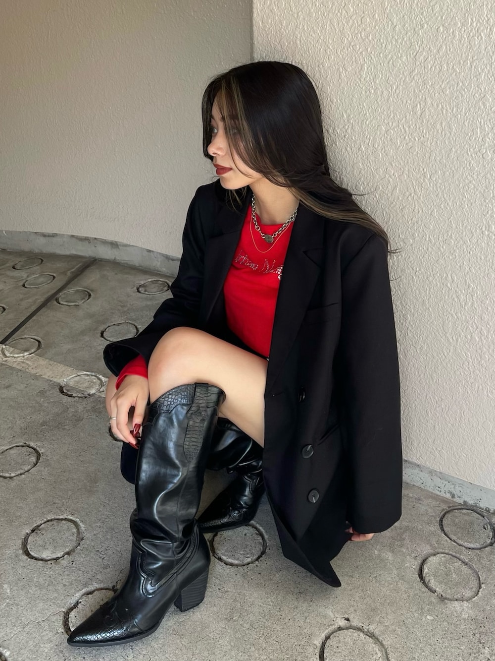 レッド系のTシャツ/カットソー、ブラック系のデニムスカート、ブラック系のブーツを着用したレディースの秋コーディネートの2枚目の写真