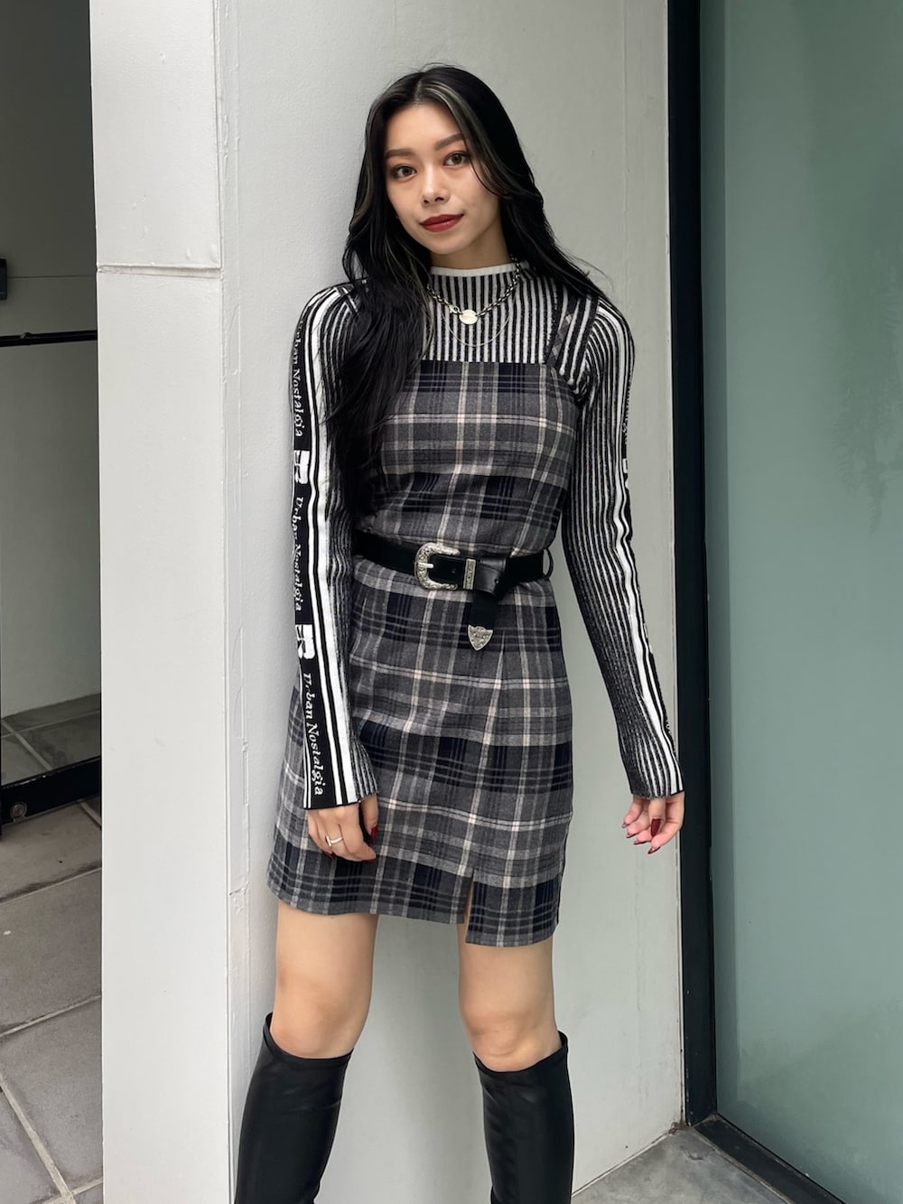 ブラック系のニット/セーター、ブラック系のワンピース、ブラック系のブーツを着用したレディースの秋コーディネートの4枚目の写真