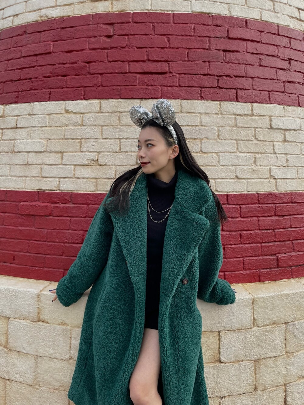 ブラック系のニット/セーター、グリーン系のチェスターコート、ブラック系のその他パンツを着用したレディースの冬コーディネートの3枚目の写真