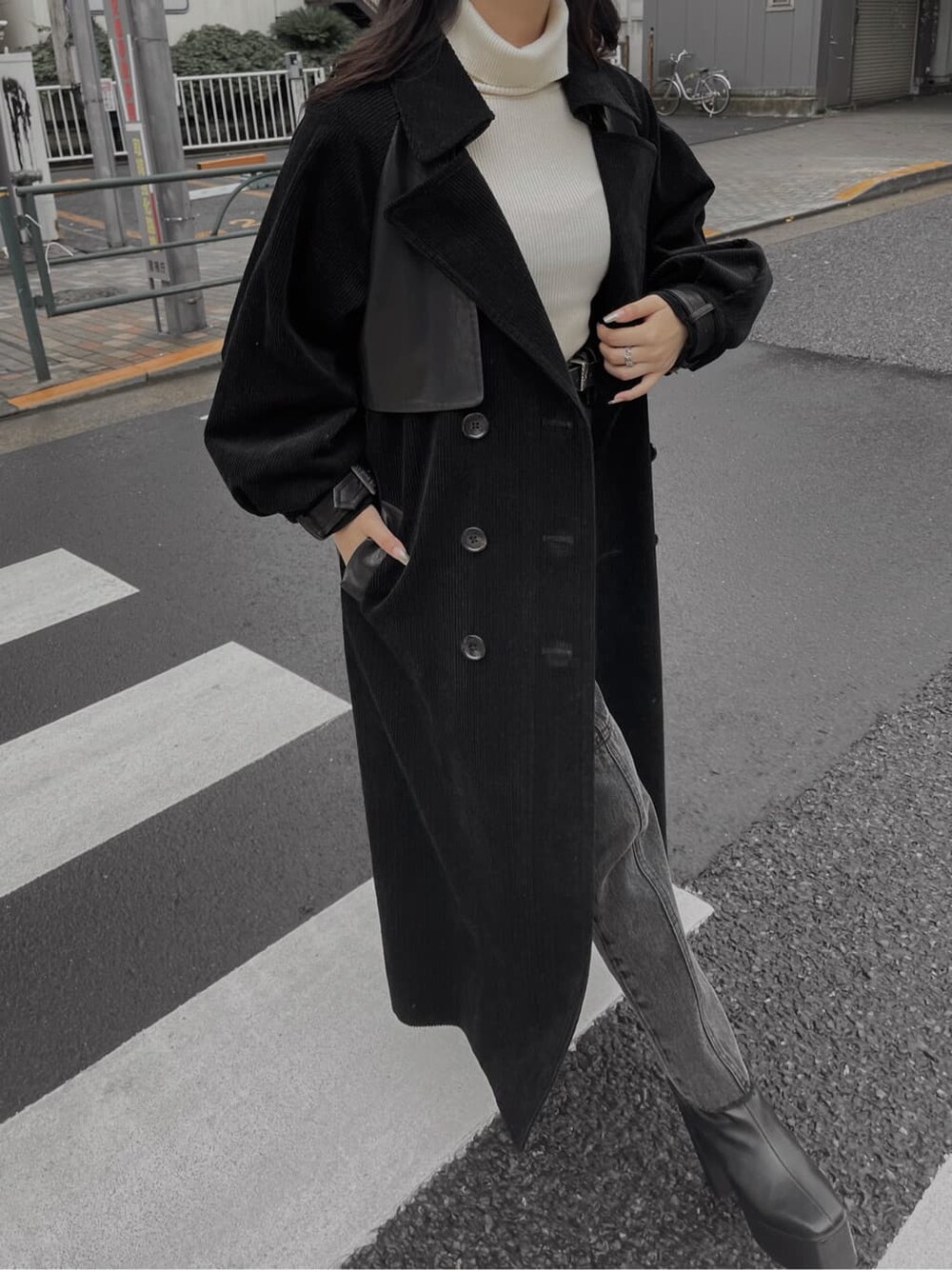 ブラック系のブーツ、ブラック系のデニムパンツ、ブラック系のトレンチコートを着用したレディースの秋コーディネートの5枚目の写真