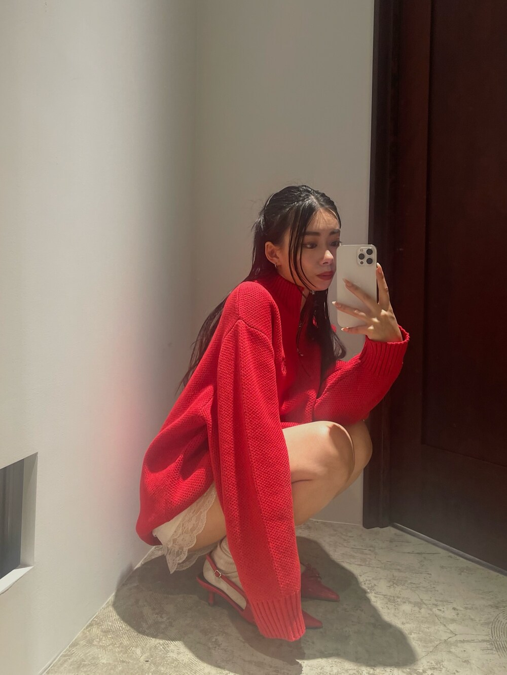 レッド系のニット/セーターを着用したレディースの夏コーディネートの2枚目の写真