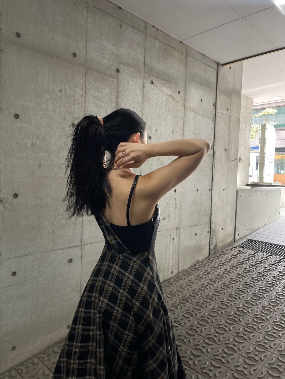 ホワイト系のベスト、ブラック系のワンピースを着用したレディースの夏コーディネートの6枚目の写真
