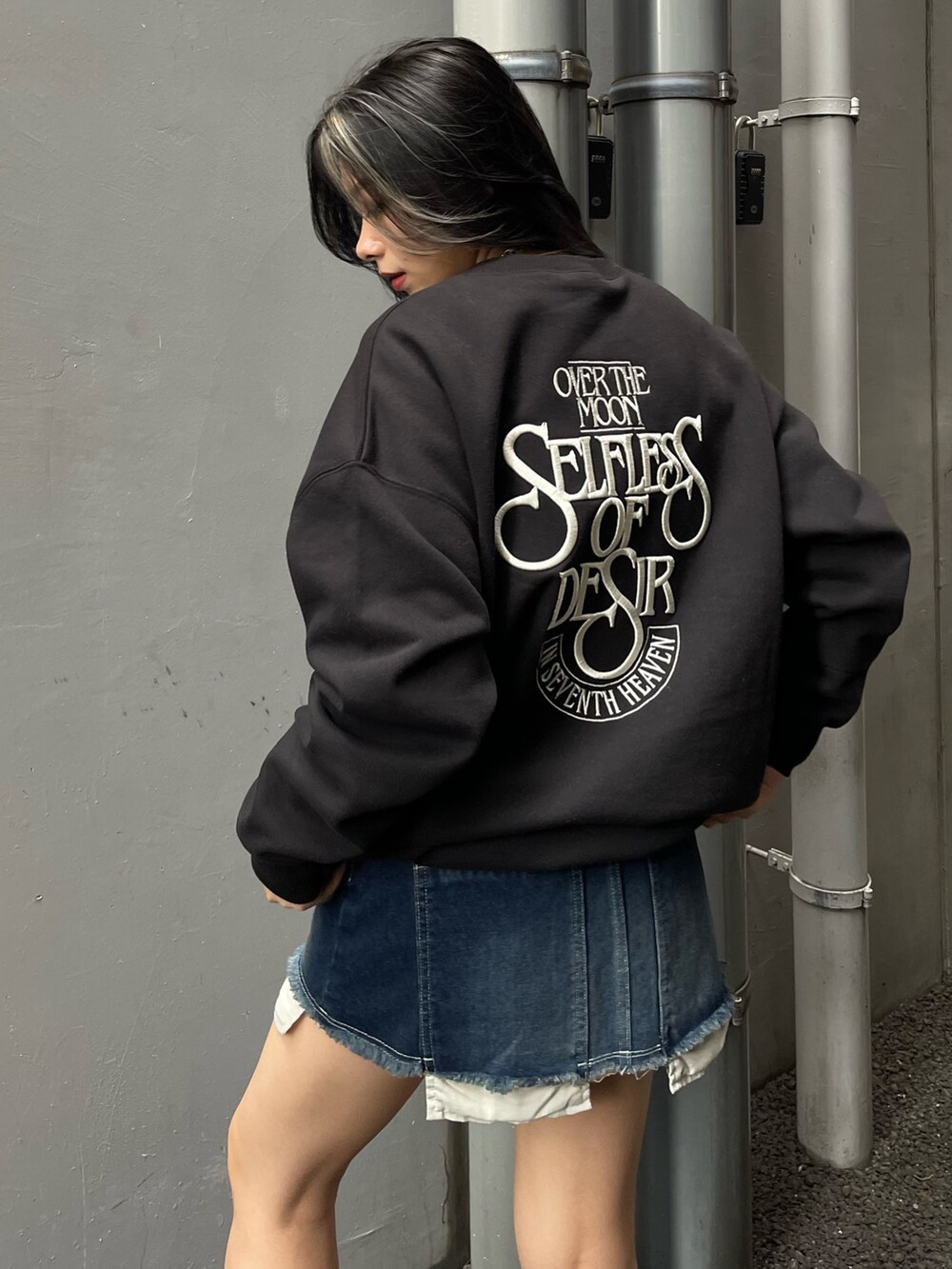 その他のチェスターコート、ブラック系のスウェット、ブルー系のデニムスカートを着用したレディースの秋コーディネートの3枚目の写真