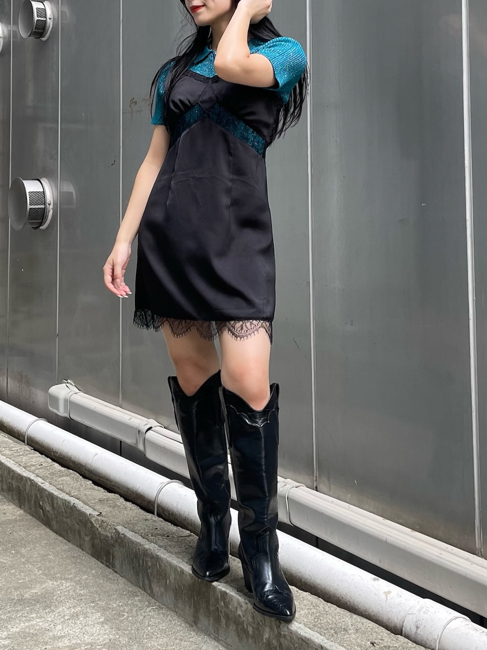 ブルー系のニット/セーター、ブラック系のワンピース、ブラック系のブーツを着用したレディースの夏コーディネートの4枚目の写真