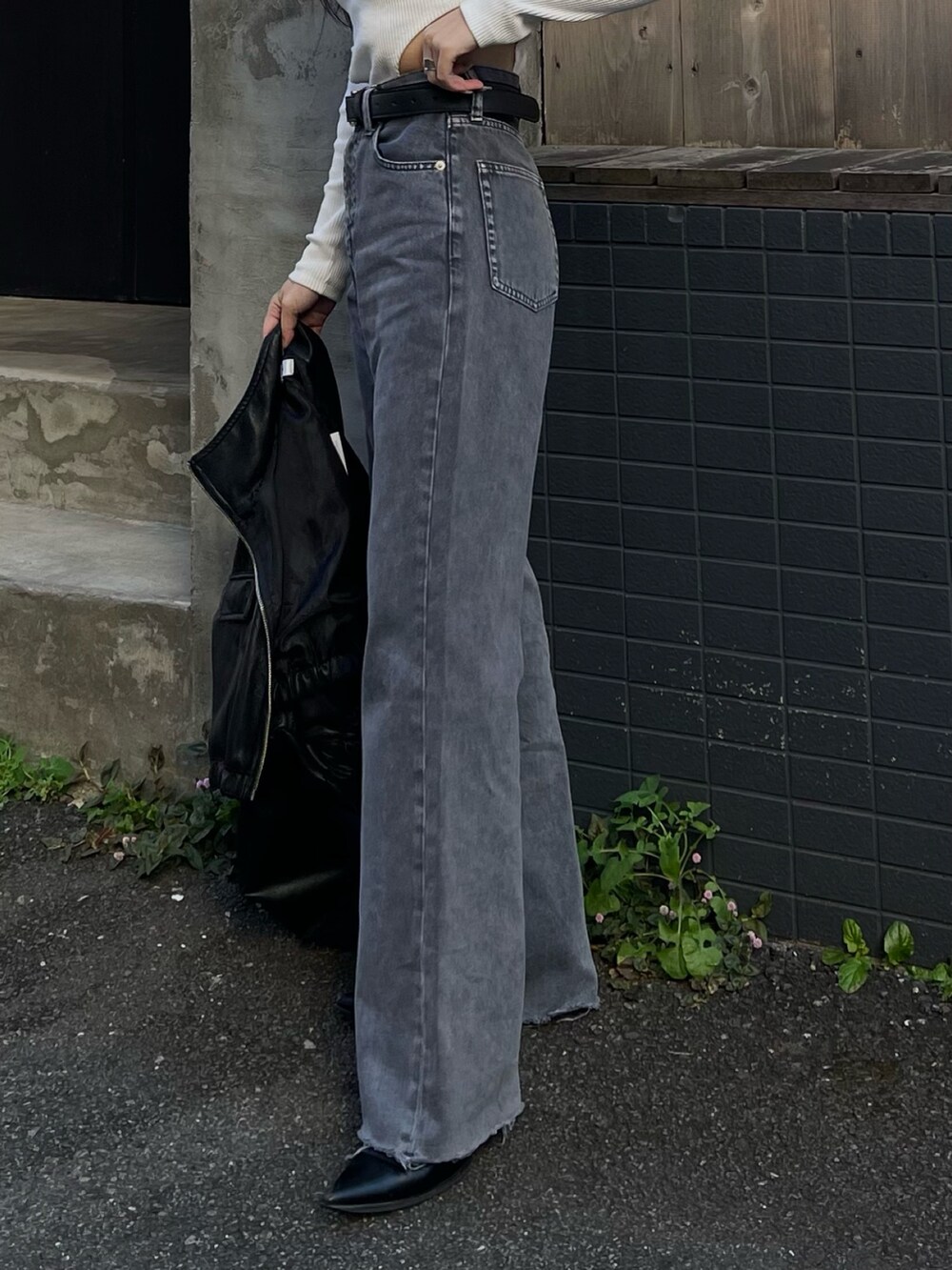 ホワイト系のTシャツ/カットソー、ブラック系のブルゾン、グレー系のデニムパンツを着用したレディースの冬コーディネートの3枚目の写真