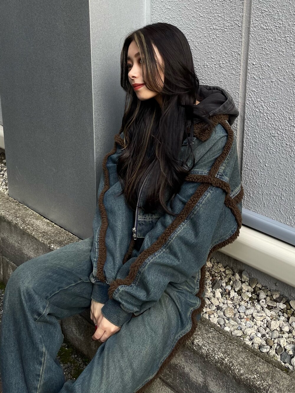 ブルー系のブルゾン、ブルー系のデニムパンツ、ブラック系のスウェットを着用したレディースの秋コーディネートの4枚目の写真