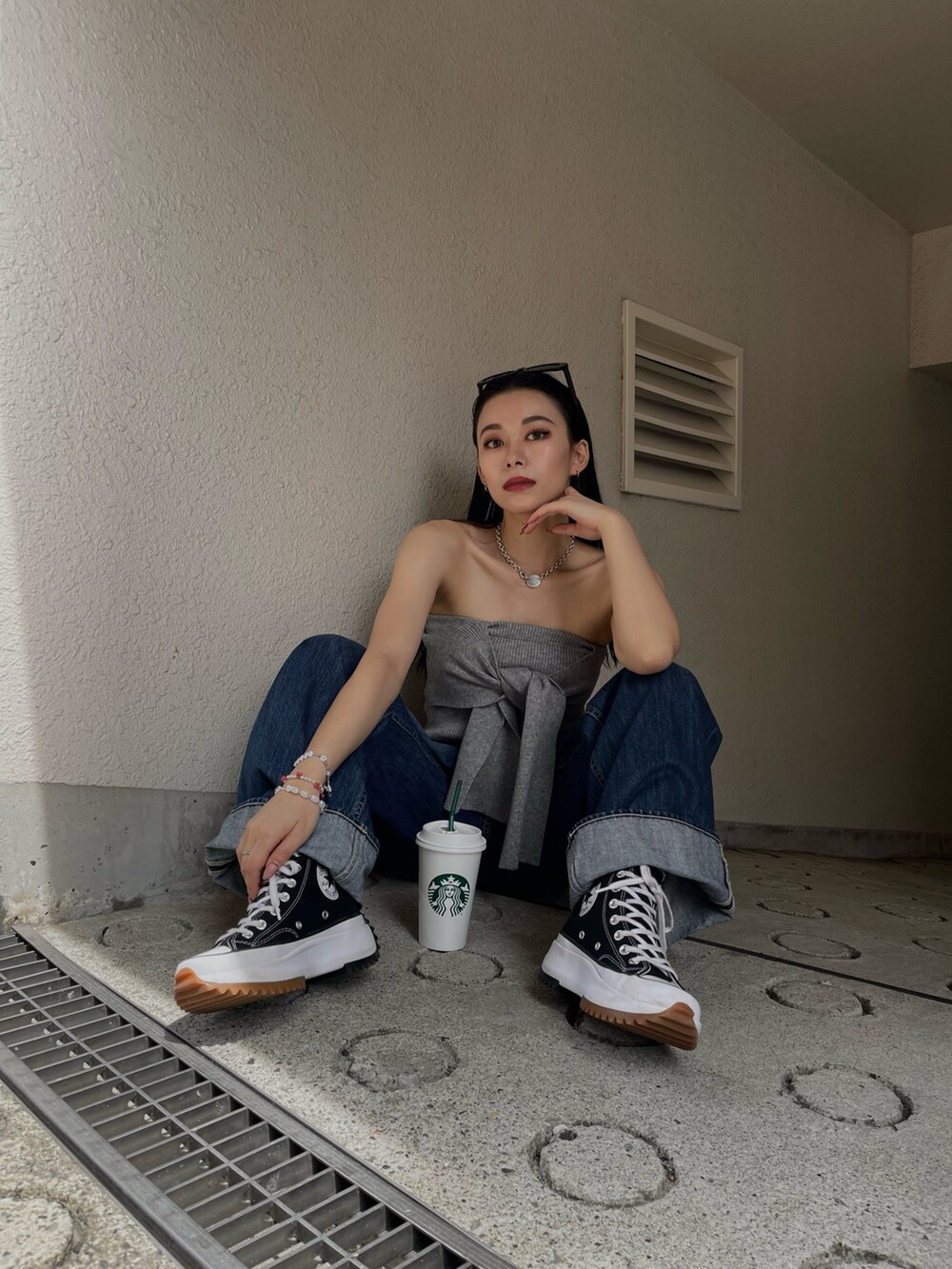 グレー系のチューブトップ、ブルー系のデニムパンツを着用したレディースの春コーディネートの3枚目の写真