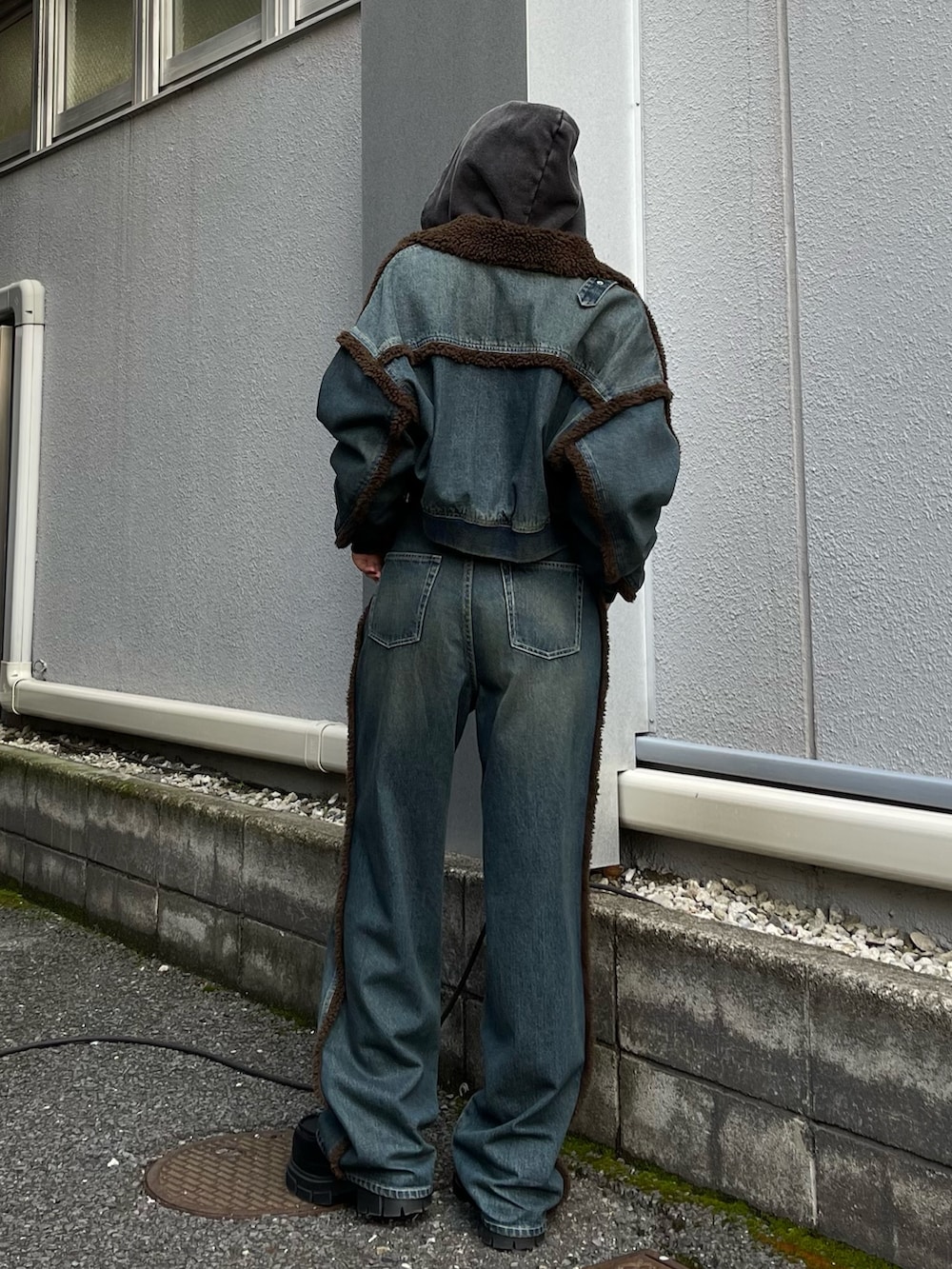 ブルー系のブルゾン、ブルー系のデニムパンツ、ブラック系のスウェットを着用したレディースの秋コーディネートの2枚目の写真