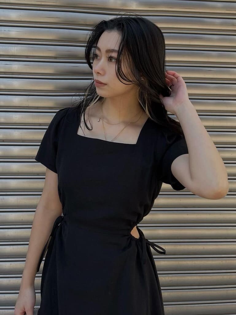 ブラック系のワンピース、ホワイト系のショルダーバッグを着用したレディースの春コーディネートの3枚目の写真