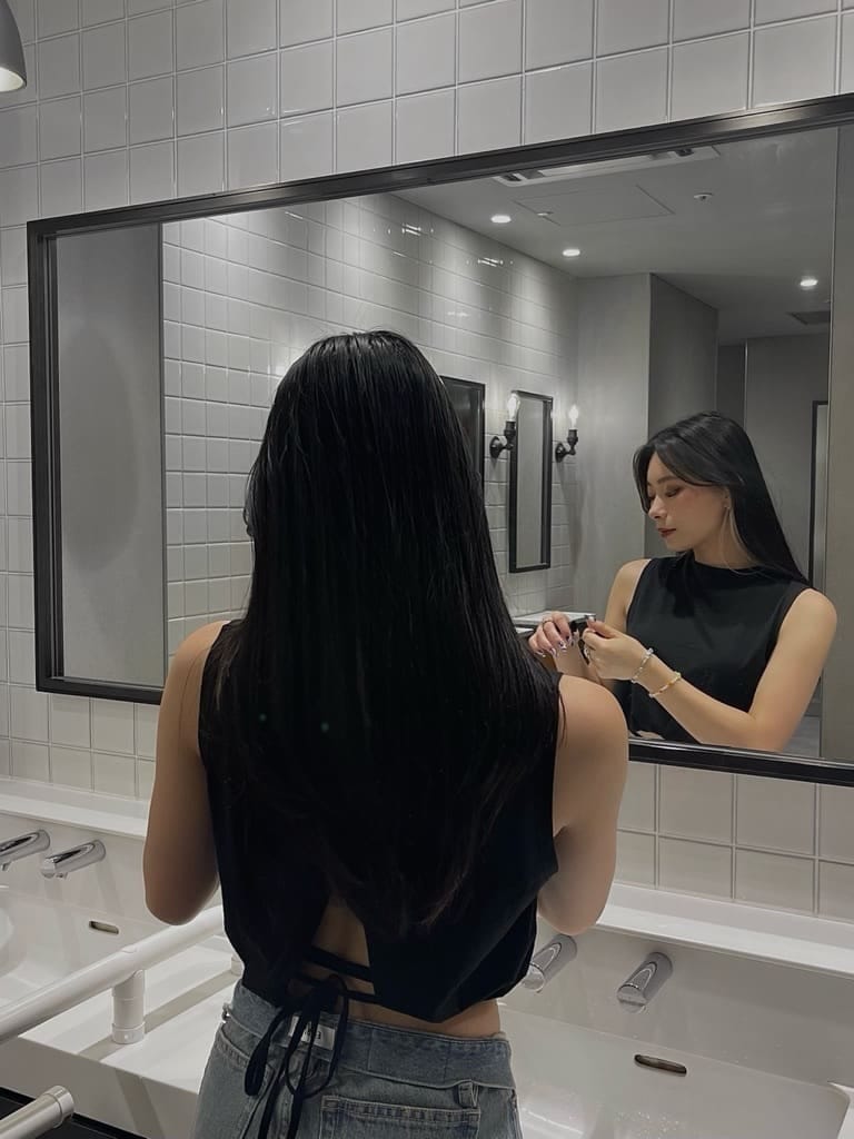 ブルー系のデニムパンツ、ブラック系のタンクトップを着用したレディースの夏コーディネートの2枚目の写真