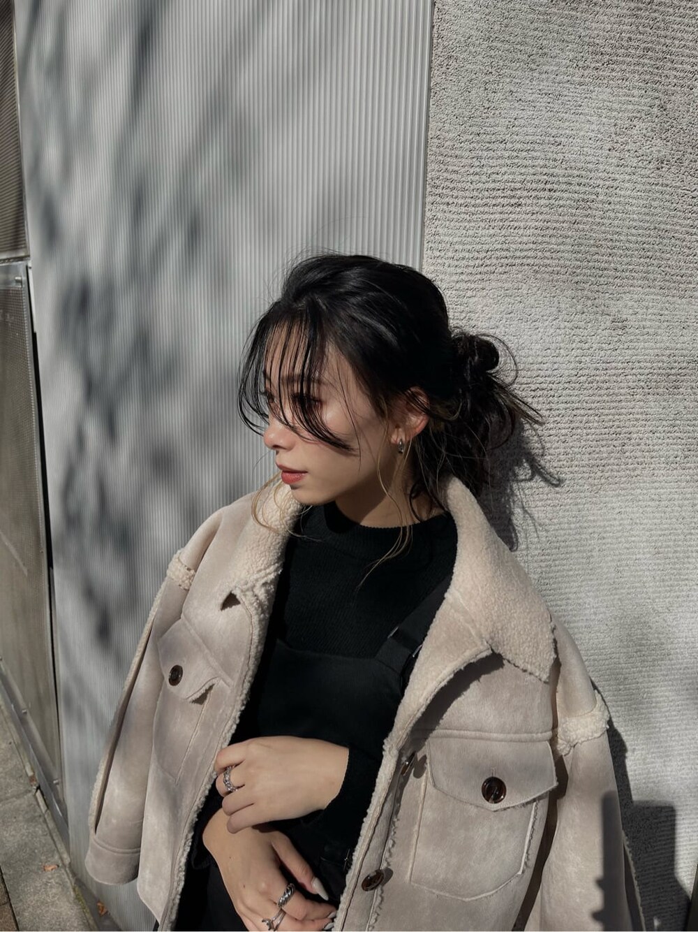 ブラック系のニット/セーター、ブラック系のブーツ、ホワイト系のブルゾンを着用したレディースの冬コーディネートの3枚目の写真