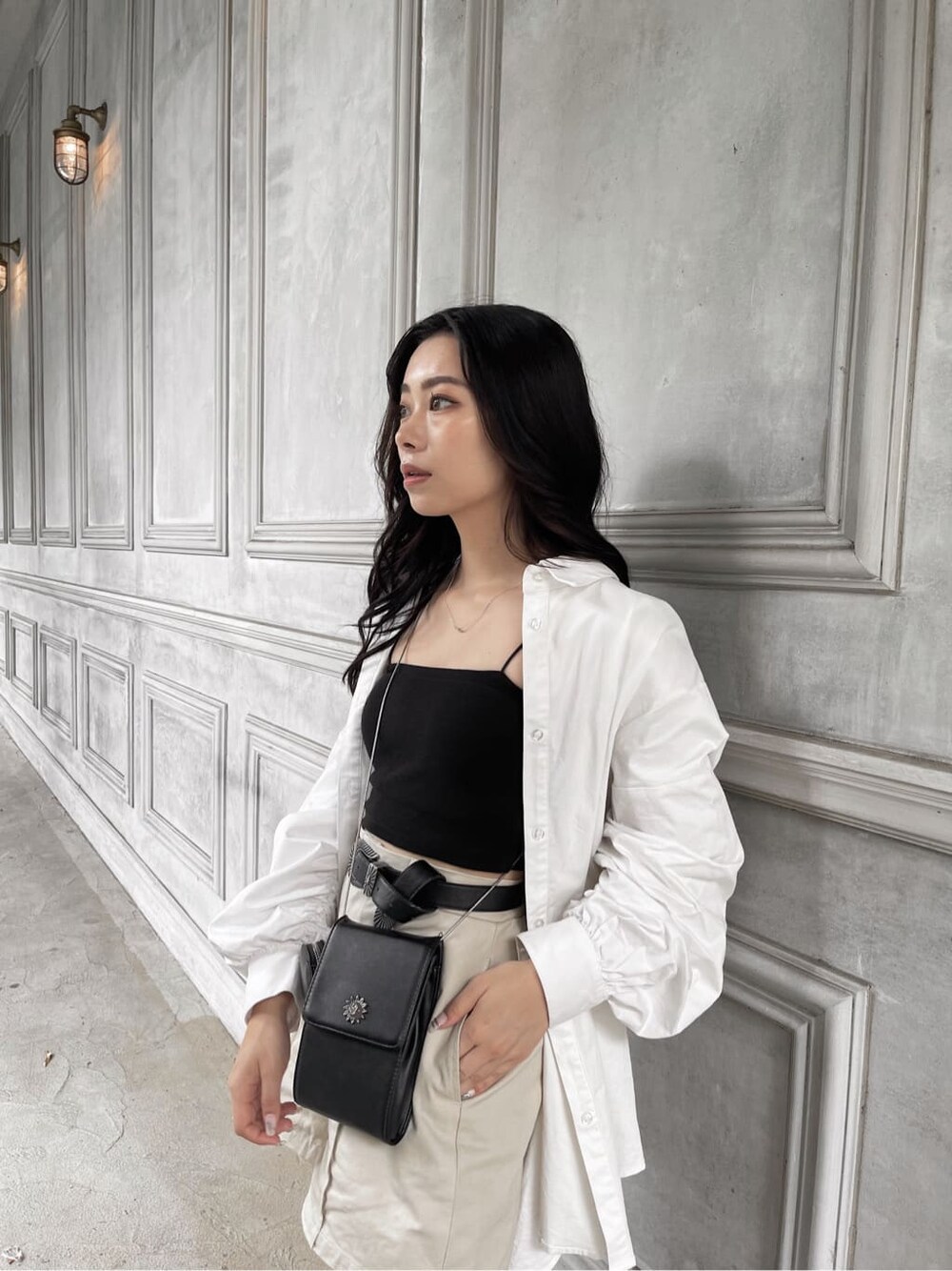 ホワイト系のシャツ/ブラウス、ブラック系のベルトを着用したレディースの夏コーディネートの2枚目の写真