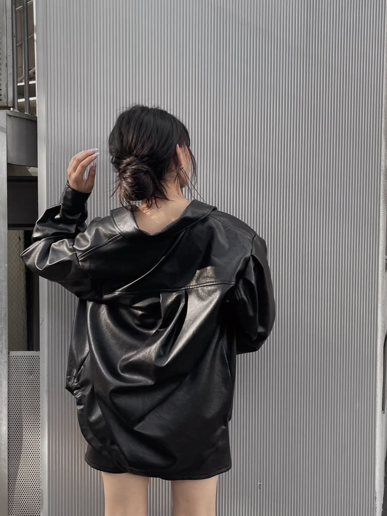 ブラック系のスカート、ブラック系のショルダーバッグ、ブラック系のブーツを着用したレディースの夏コーディネートの5枚目の写真