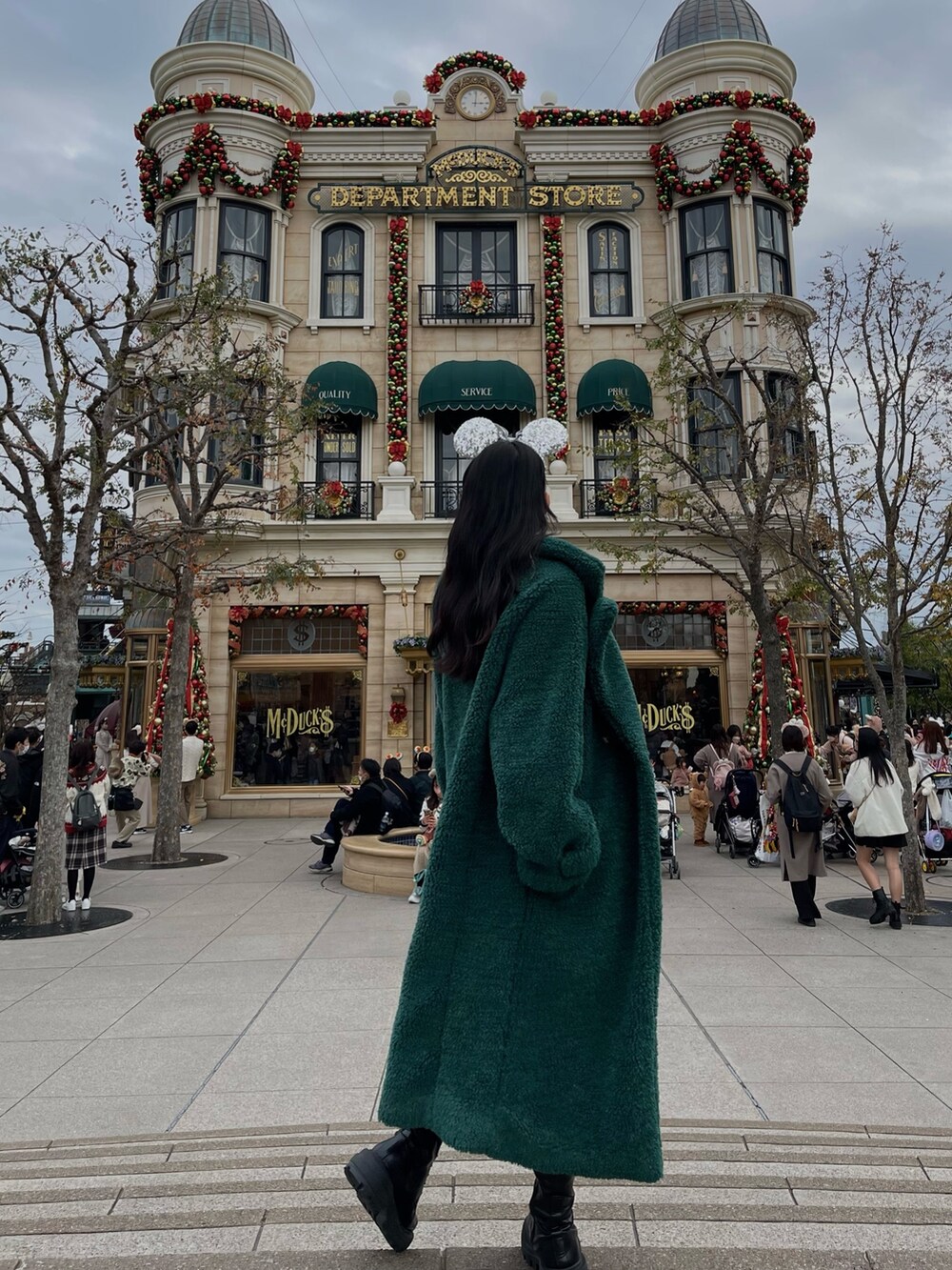 ブラック系のニット/セーター、グリーン系のチェスターコート、ブラック系のその他パンツを着用したレディースの冬コーディネートの2枚目の写真