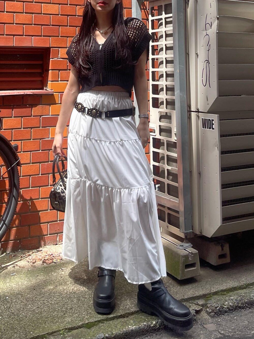 ブラック系のニット/セーター、その他のショルダーバッグ、ブラック系のブーツを着用したレディースの春コーディネートの2枚目の写真