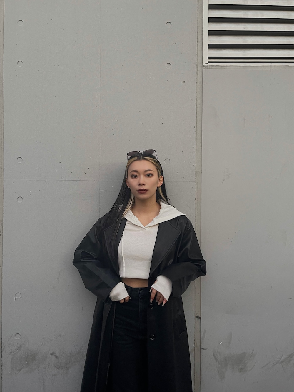 ブラック系のチェスターコート、レッド系のブーツ、ブラック系のデニムパンツを着用したレディースの冬コーディネートの4枚目の写真