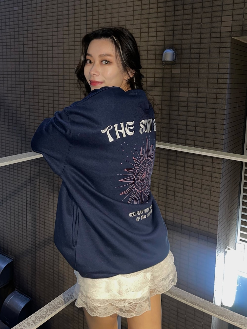 ブルー系のスウェット、ブラック系のスニーカーを着用したレディースの冬コーディネートの3枚目の写真