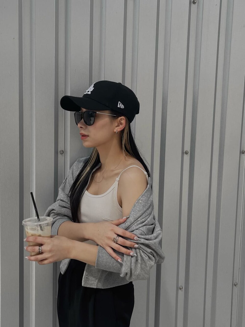 ブラック系のスラックス、グレー系のカーディガン/ボレロ、ホワイト系のキャミソールを着用したレディースの春コーディネートの7枚目の写真