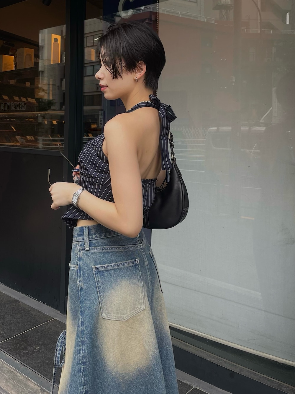 ブルー系のデニムスカート、ブラック系のブーツを着用したレディースの夏コーディネートの3枚目の写真