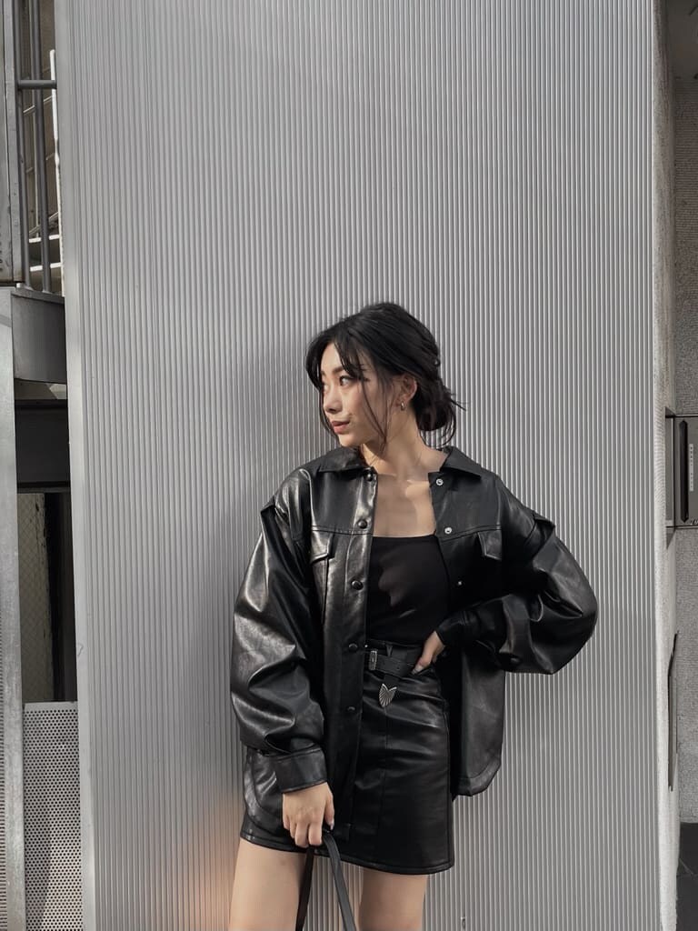 ブラック系のスカート、ブラック系のショルダーバッグ、ブラック系のブーツを着用したレディースの夏コーディネートの4枚目の写真