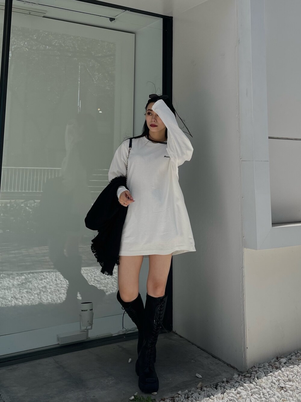 ホワイト系のTシャツ/カットソー、ブラック系のベスト、ブラック系のブーツを着用したレディースの夏コーディネートの4枚目の写真