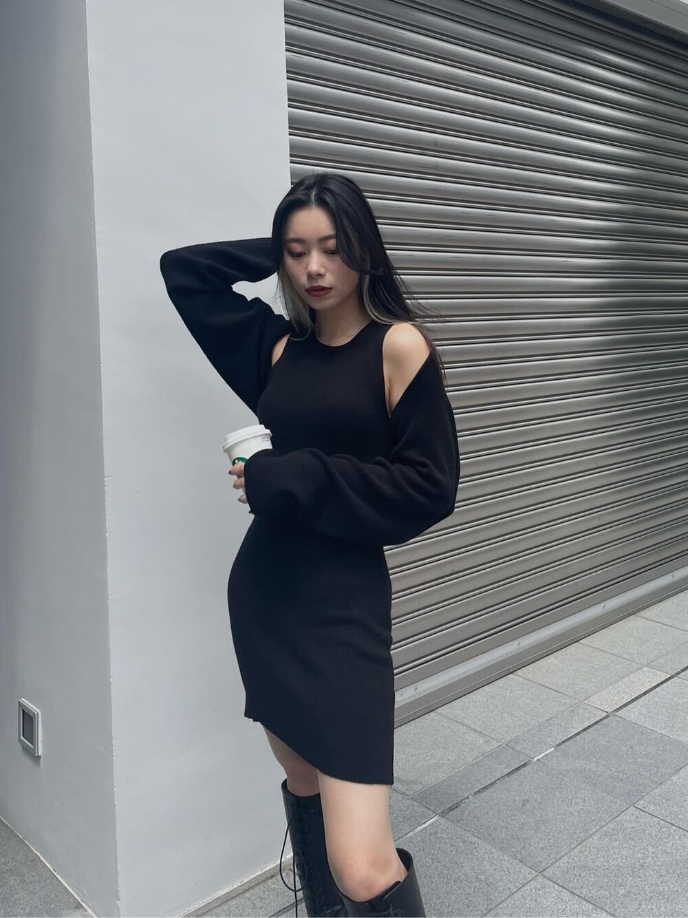 ブラック系のブーツ、ブラック系のワンピース、ブラック系のボストンバッグを着用したレディースの秋コーディネートの6枚目の写真