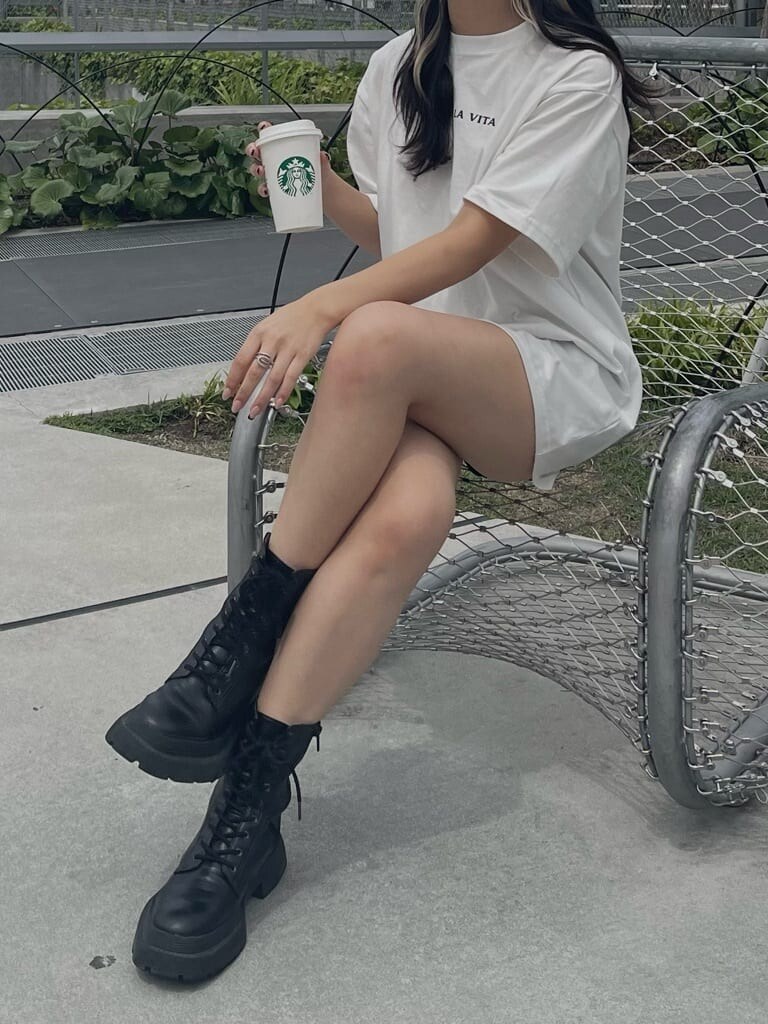 ブラック系のブーツ、ホワイト系のTシャツ/カットソーを着用したレディースの夏コーディネートの3枚目の写真
