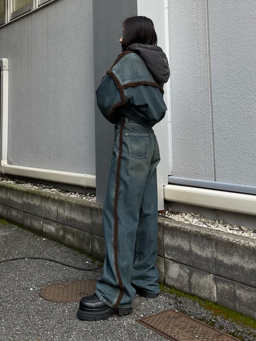 ブルー系のブルゾン、ブルー系のデニムパンツ、ブラック系のスウェットを着用したレディースの秋コーディネートの3枚目の写真