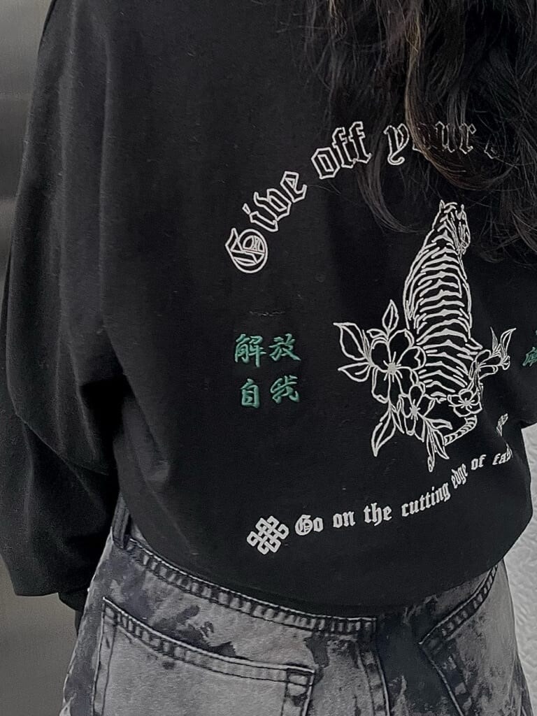 ブラック系のデニムパンツ、ブラック系のブーツ、ブラック系のTシャツ/カットソーを着用したレディースの冬コーディネートの5枚目の写真