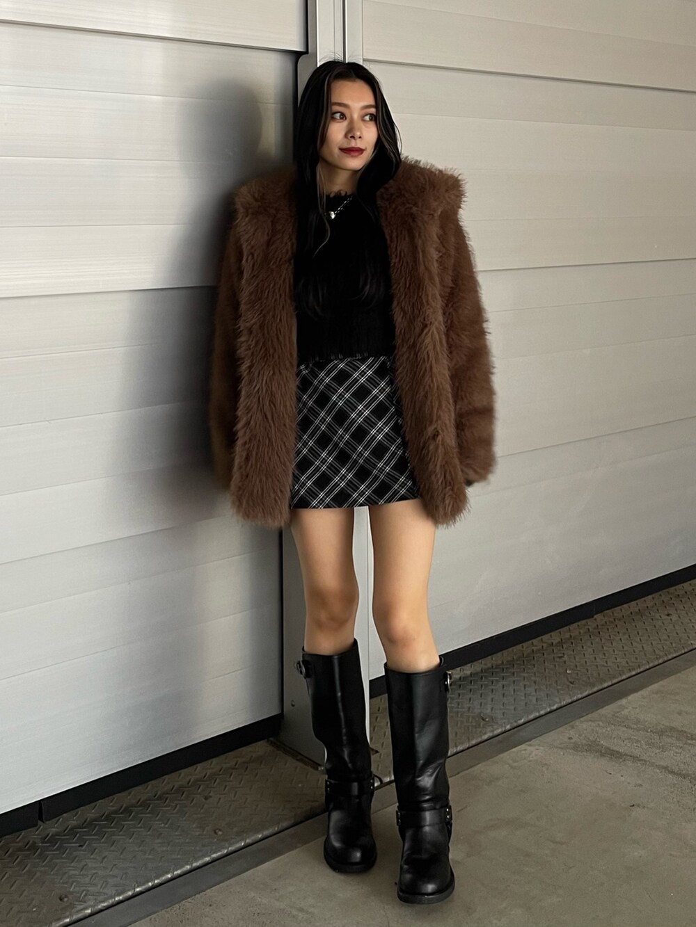 ブラウン系のブルゾン、ブラック系のニット/セーター、ブラック系のスカートを着用したレディースの秋コーディネートの5枚目の写真