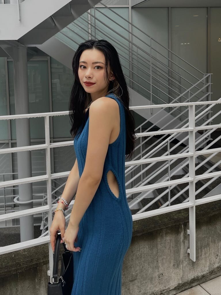 ブルー系のワンピース、ブラック系のハンドバッグ、ブラック系のブーツを着用したレディースの秋コーディネートの2枚目の写真