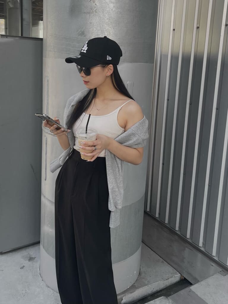 ブラック系のスラックス、グレー系のカーディガン/ボレロ、ホワイト系のキャミソールを着用したレディースの春コーディネートの5枚目の写真