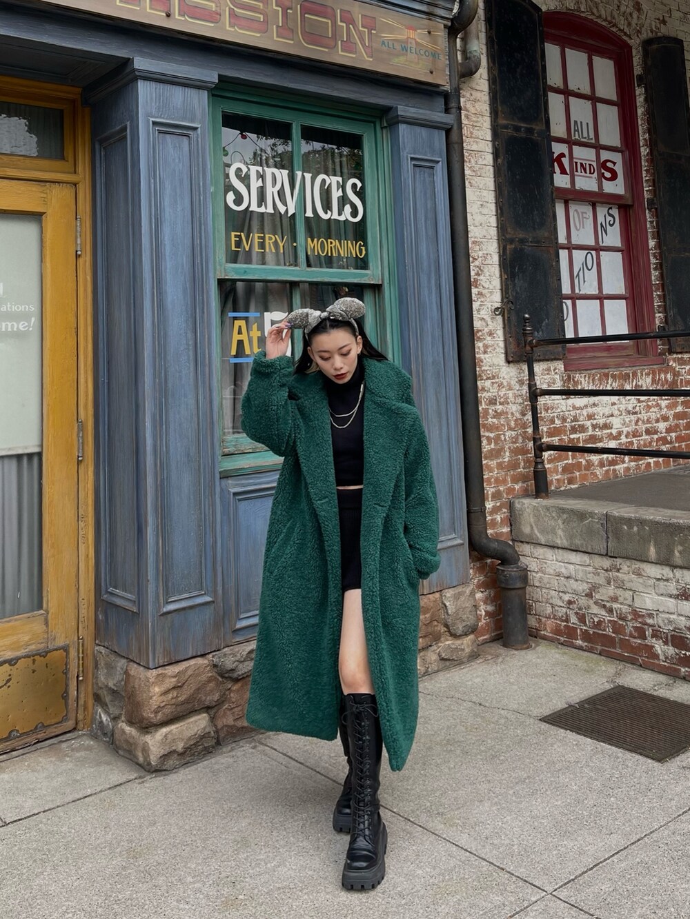ブラック系のニット/セーター、グリーン系のチェスターコート、ブラック系のその他パンツを着用したレディースの冬コーディネートの4枚目の写真
